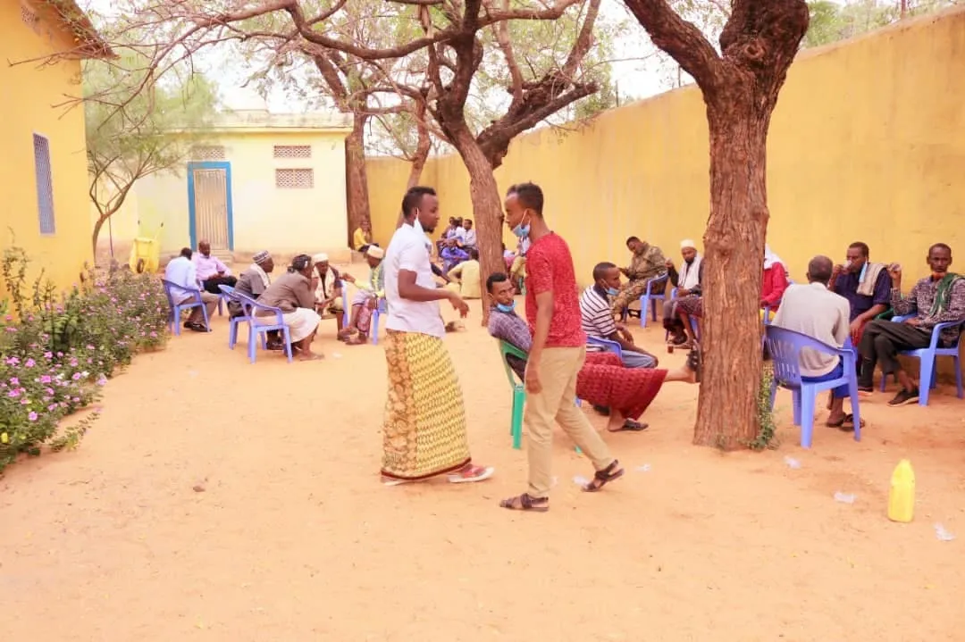 Community members gathered outdoors during a civic education activity in Diinsoor